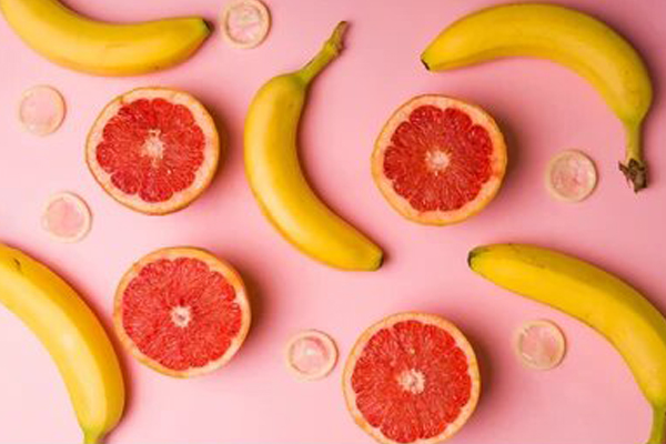 picture of grapefruit and bananas on pink background also