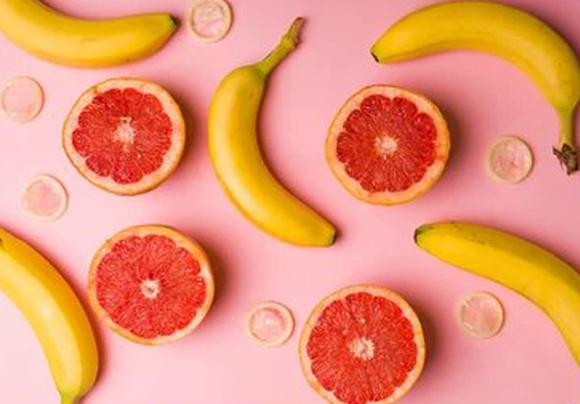 picture of grapefruit and bananas on pink background